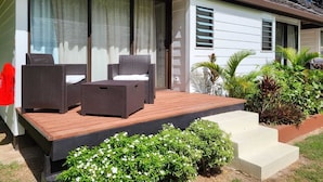 A modern house with a covered porch, outdoor seating, and a small garden. - FARE MANTA (Moorea-Maiao)