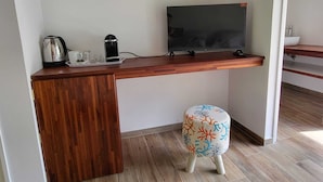 A small kitchenette with a wooden countertop, a television, a kettle, and a coffee maker. - FARE MANTA (Moorea-Maiao)
