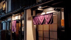 En traditionell japansk byggnad med en träfasad och en skjutdörr.