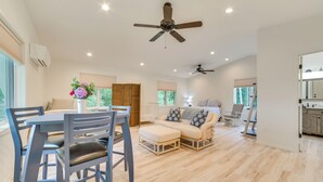 A spacious living area with a dining table, chairs, a sofa, and a ceiling fan. - Lakefront Escape on Beautiful Burt Lake! (Alanson)