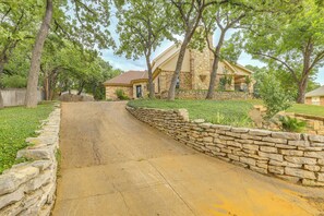 Set amidst mature trees and a well-maintained lawn, this serene property offers an entrance via a paved driveway.