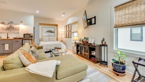 A modern living room with a sofa, a coffee table, and a dining area with a lamp. - WFH-Friendly Studio - 5 Mi to Downtown Atlanta! (Atlanta)