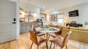 A modern kitchen with a dining area, a sofa, and a TV in a living room. - WFH-Friendly Studio - 5 Mi to Downtown Atlanta! (Atlanta)
