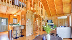 A wooden interior with a staircase, a kitchen area, and a seating area with a sofa and chairs. - Lake Keowee Retreat: Idyllic Six Mile Cabin! (Six Mile)