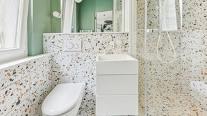 A bathroom with a white sink, a toilet, and a shower area. - Art and comfort near the Bastille (Paris)