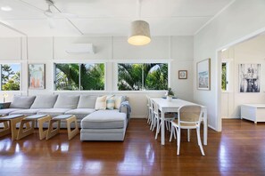 Un salon moderne comprenant un canapé, une table à manger, des chaises et des œuvres d’art accrochées aux murs.