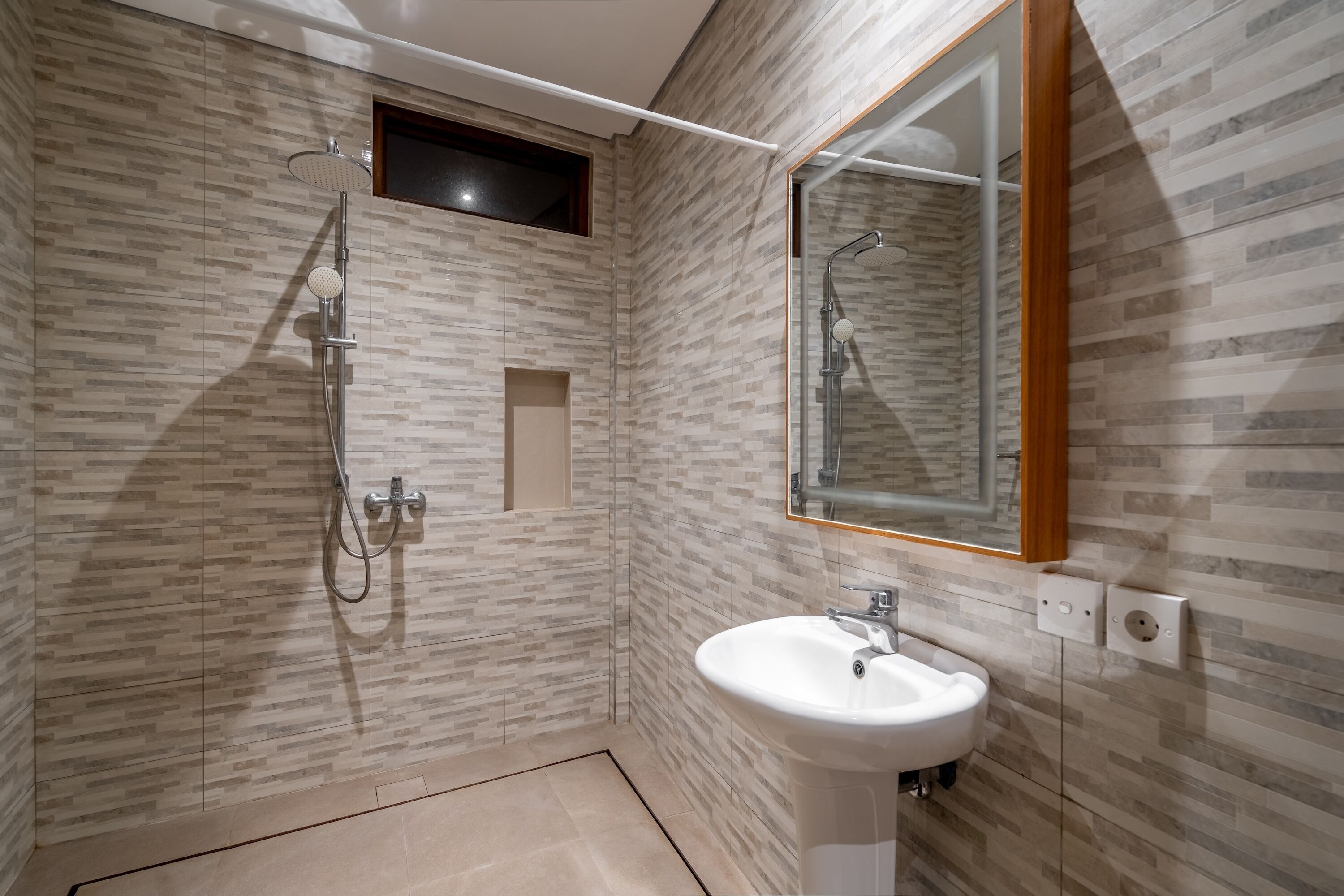 A modern bathroom with a shower, sink, and a mirror.