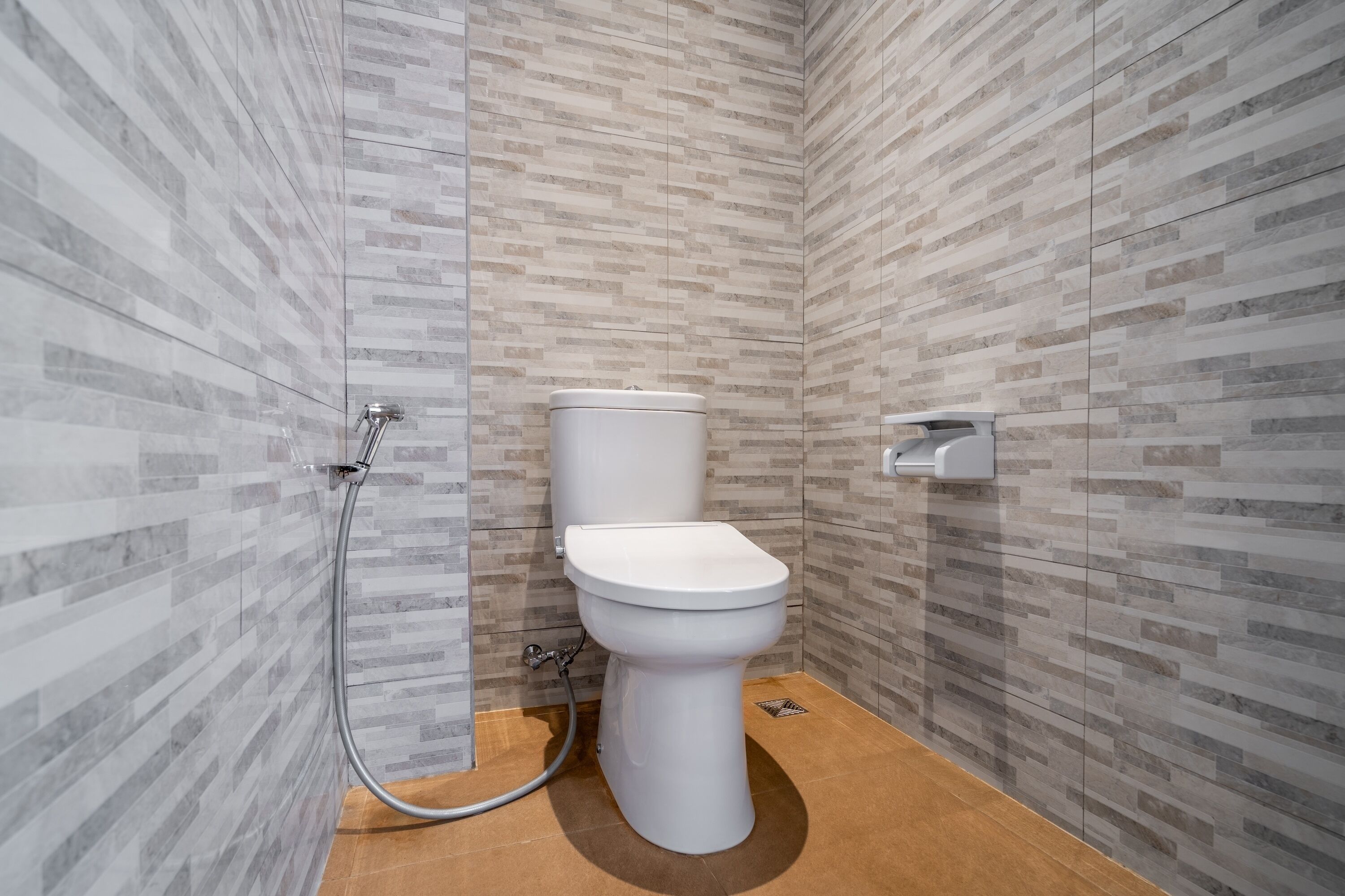 Ein modernes Badezimmer mit Toilette, Dusche und Fliesen.