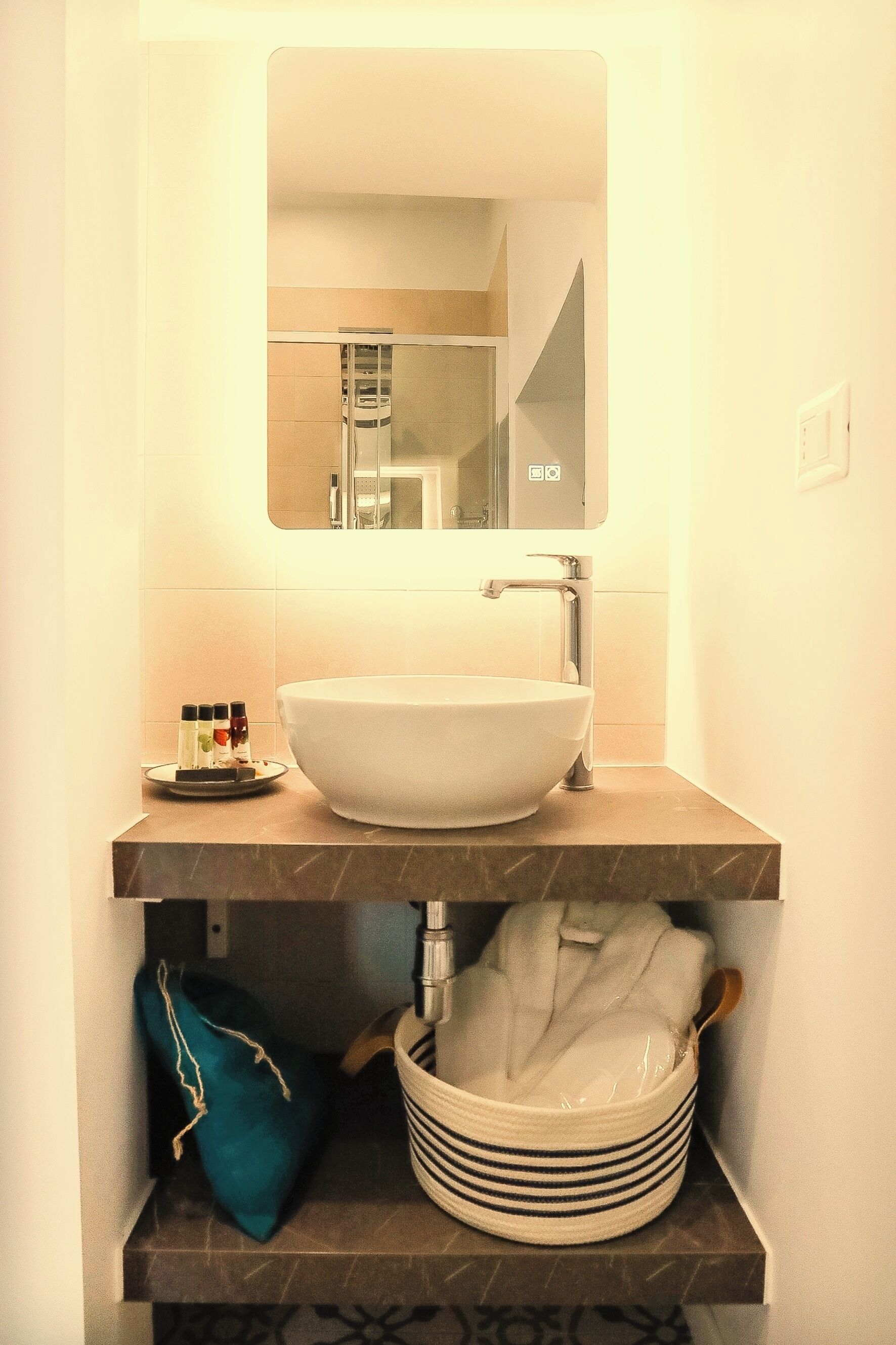 A bathroom with a white sink, a mirror, and a towel rack.