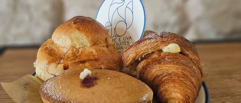 A plate with three pastries, a coffee cup, and a logo on a napkin.