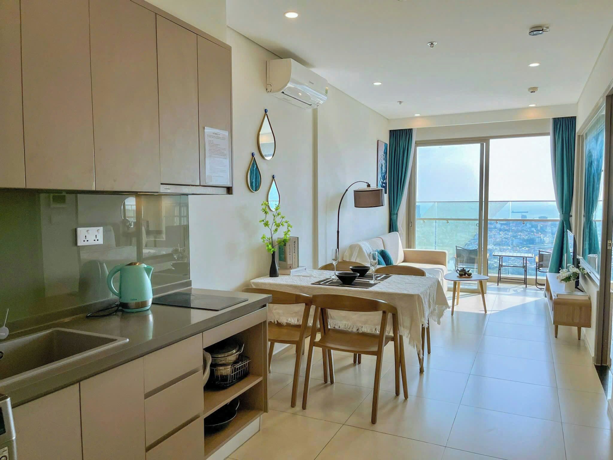 Una cocina moderna con comedor, vista al mar y balcón con mesa y sillas.