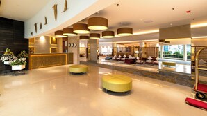 A spacious lobby with a reception desk, seating areas, and a decorative wall with bird sculptures. - TIARA BY MPS (Kozhikode)
