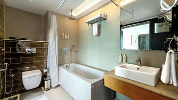 A modern bathroom with a bathtub, toilet, and sink.