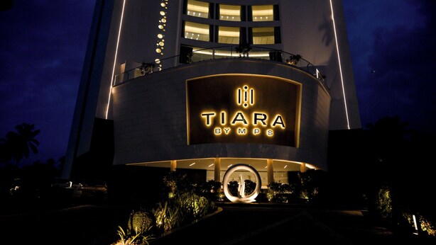 A modern hotel with a prominent illuminated sign reading "TIARA BYMPS". - TIARA BY MPS (Kozhikode)