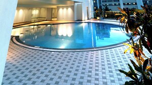 A modern building with a pool, large windows, and a tiled floor. - TIARA BY MPS (Kozhikode)