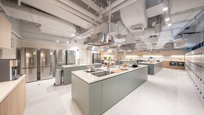 A modern kitchen with stainless steel appliances, a central island, and a view of the dining area. - Weave Studios - Kowloon West (Kowloon)