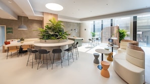 A modern interior with a central island, seating area, and large windows. - Weave Studios - Kowloon West (Kowloon)