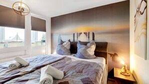 Een hotelkamer met een groot bed, uitzicht op de stad en een schilderij aan de muur.