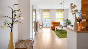 A modern living room with a sofa, a coffee table, and a dining area.