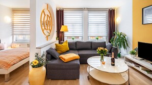 Una sala de estar moderna con un sofá, una mesa de centro, un televisor y una cama.
