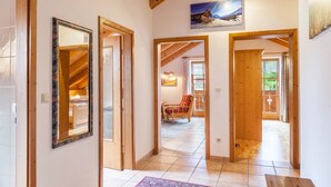 Un couloir avec des portes en bois, un tapis et un tableau accroché au mur.