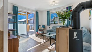 Un salon moderne comprenant un canapé, une table basse, un fauteuil, une bibliothèque et une cheminée.