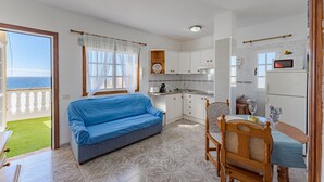 Ein gemütlicher Wohnbereich mit Sofa, Esstisch und Küchenzeile.