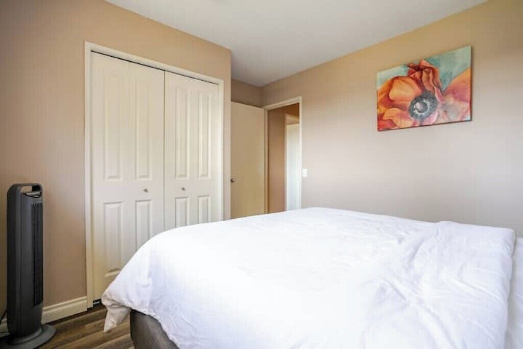 Une chambre à coucher avec un lit, un radiateur et une porte.