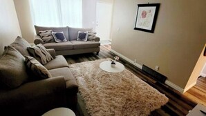 A living room with a sofa, a coffee table, and a rug. - Tranquil Home in Bracewood Community of Calgary Southwest Alberta. (Calgary)