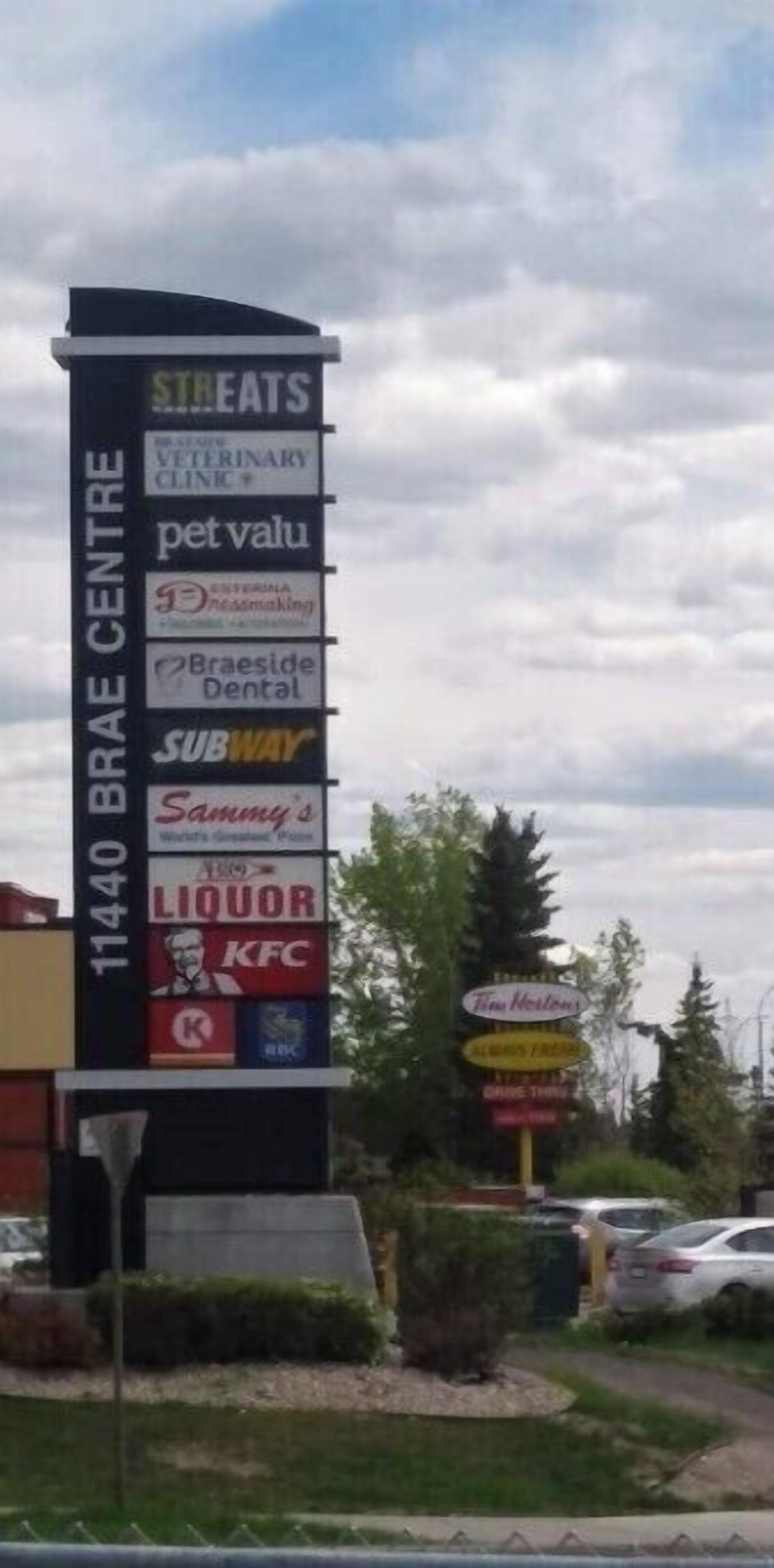 A commercial building with a sign listing various businesses including a veterinary clinic, pet valuation, and a Subway.