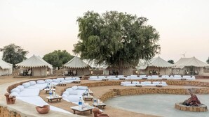 A desert resort with multiple tents, outdoor seating areas, and a central fire pit. - Golden Rose Heritage Desert Safari Camp  (Jaisalmer)