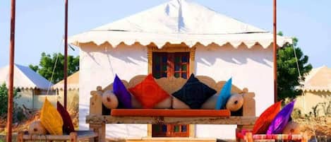 Una tienda tradicional con un área de estar acolchada al frente, una ventana pequeña y una baranda decorativa.