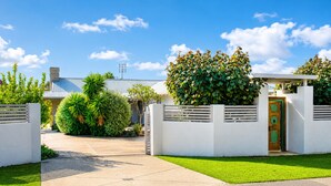 A residential property with a gated entrance, a well-maintained lawn, and a house with a metal roof. - Gifford Getaway (Dunsborough)