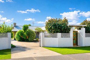 A residential property with a gated entrance, a well-maintained lawn, and a house with a metal roof. - Gifford Getaway (Dunsborough)