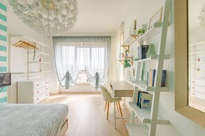 Une chambre à coucher comprenant un lit, un bureau, une chaise, une armoire et une bibliothèque.