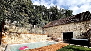 A stone building with a tiled roof, a swimming pool, and a wooden deck. - La Grange aux Souvenirs - Perigord Noir (Les Coteaux Périgourdins)