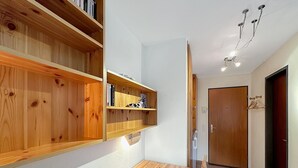 A compact room with a wooden dining table and chairs, a bookshelf, and a door. - Haus Cresta - Zermatt Paradise- Swiss Alps (Zermatt)