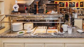 Una barra de buffet con distintos alimentos y utensilios.