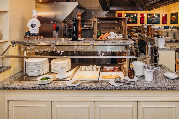 A buffet setup with various food items and utensils.