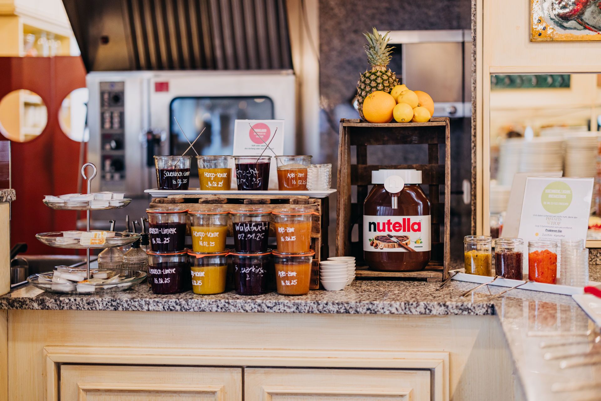 A kitchen counter with various jars of condiments and a large jar of Nutella.