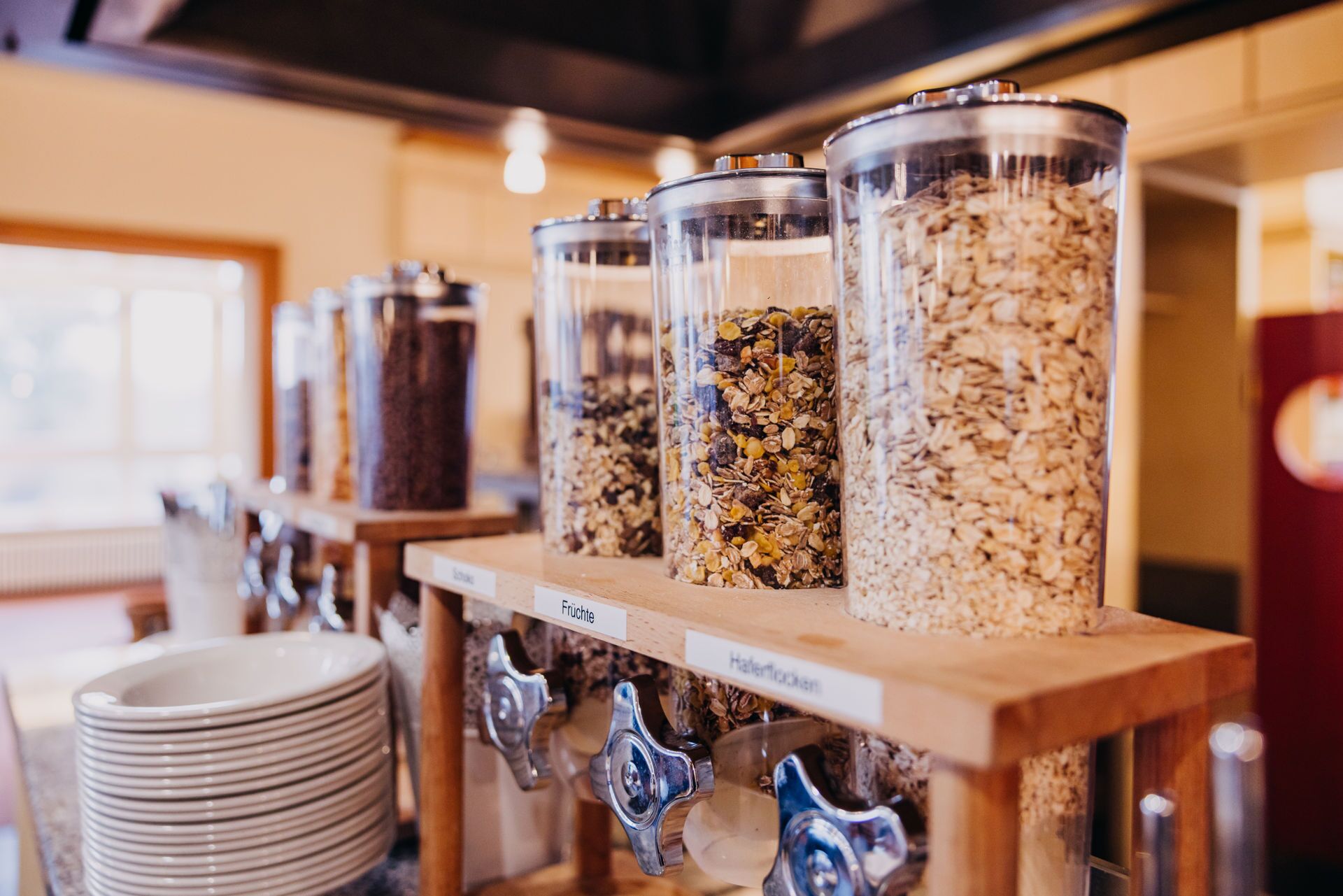 A food dispensing station with multiple containers of granola and other snacks.