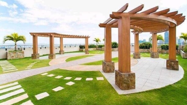 A landscaped outdoor area with wooden pergolas and a paved walkway. - Sunshine 100 Plaza (Mandaluyong)