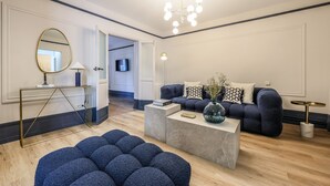 A modern living room with a sofa, ottoman, coffee table, and a mirror.