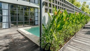 A modern building with large windows, a pool, and a wooden deck. - Berawa Loft 10 by Betterplace (Canggu)