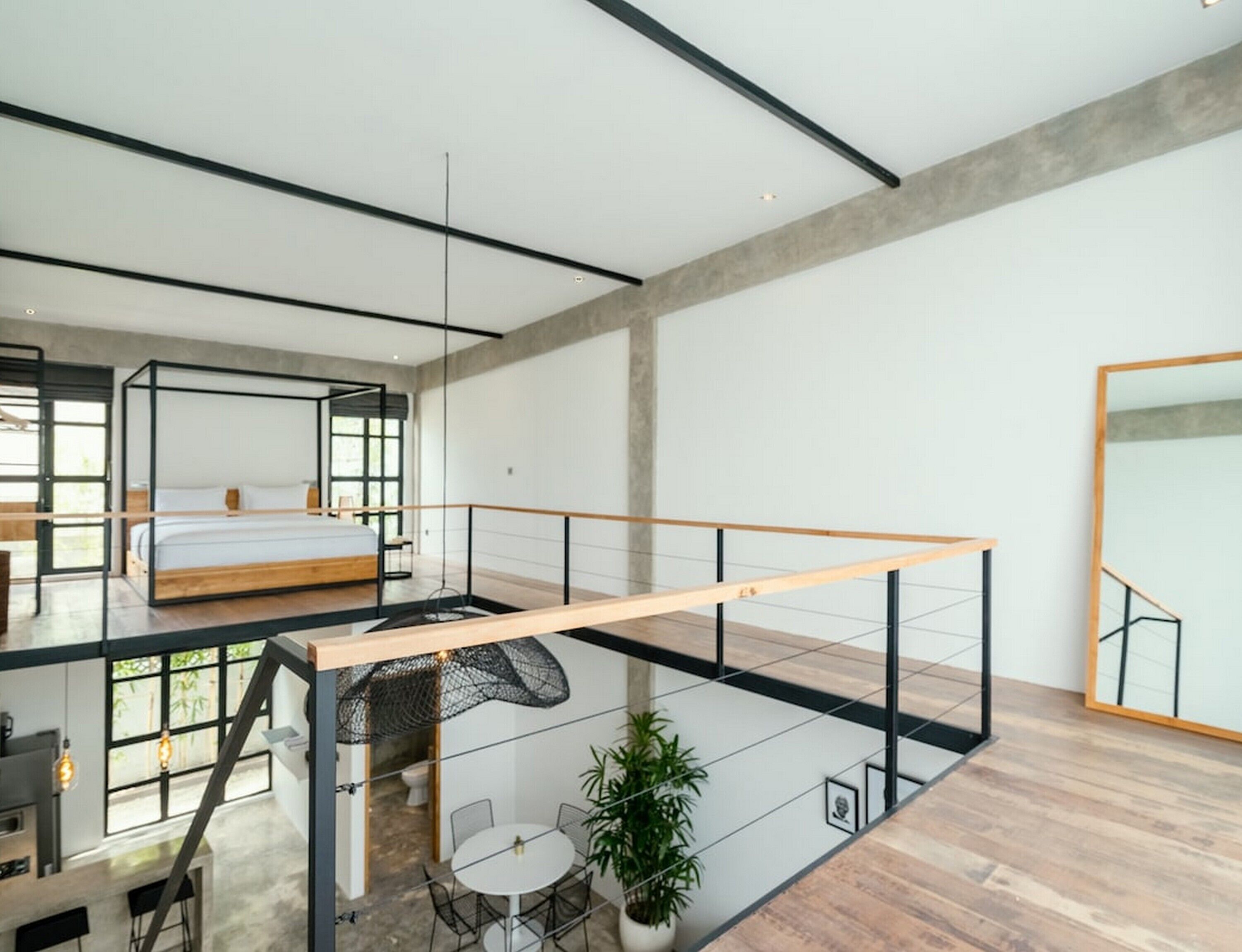 Un interior moderno con un dormitorio amplio, un balcón con zona de comedor y vistas al exterior.
