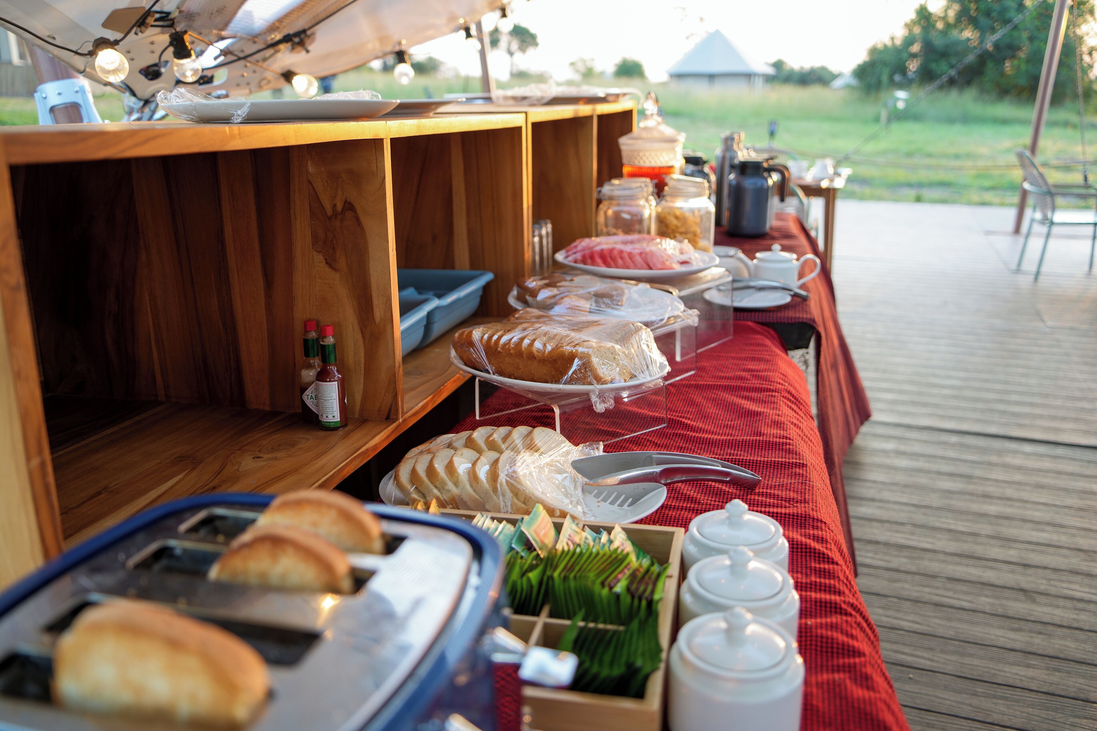 A buffet setup with various food items and utensils on a wooden table.