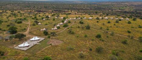 A rural landscape with a series of small, uniform buildings, likely guesthouses, arranged in a line across a hilly terrain.