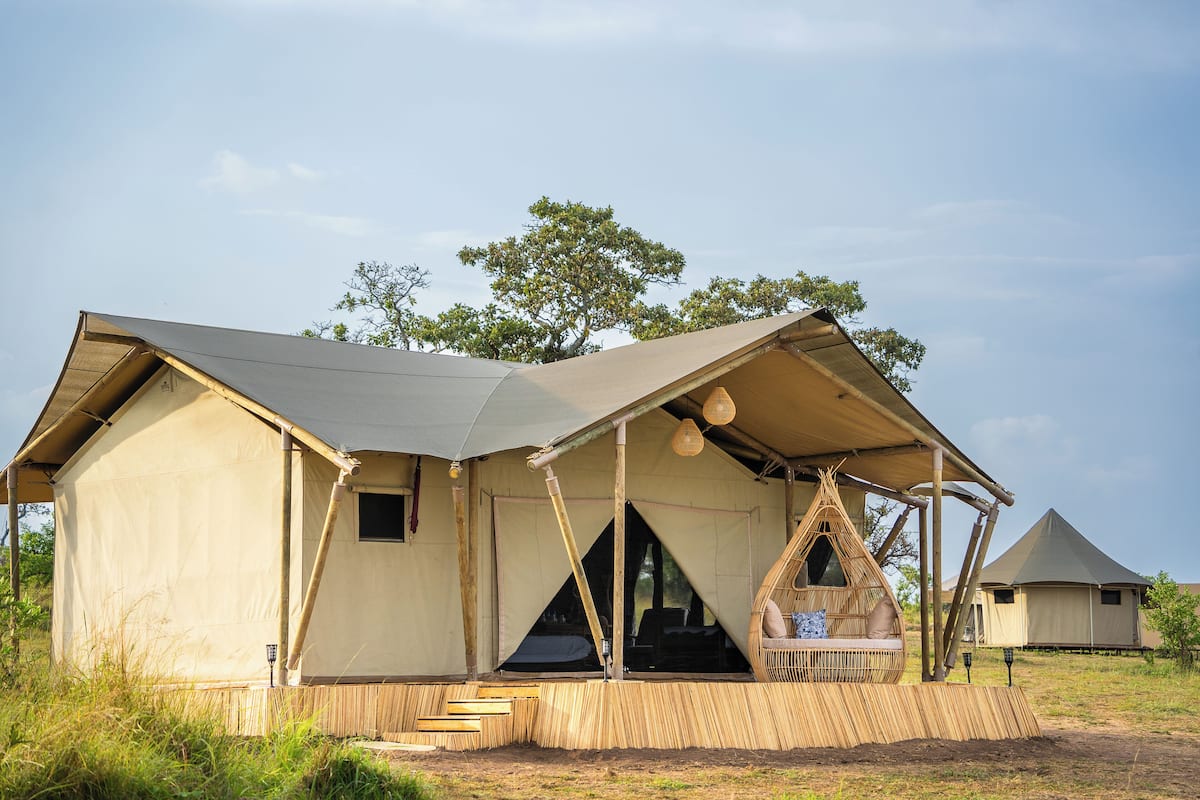 Una carpa safari con una zona de estar cubierta y una pequeña ventana.