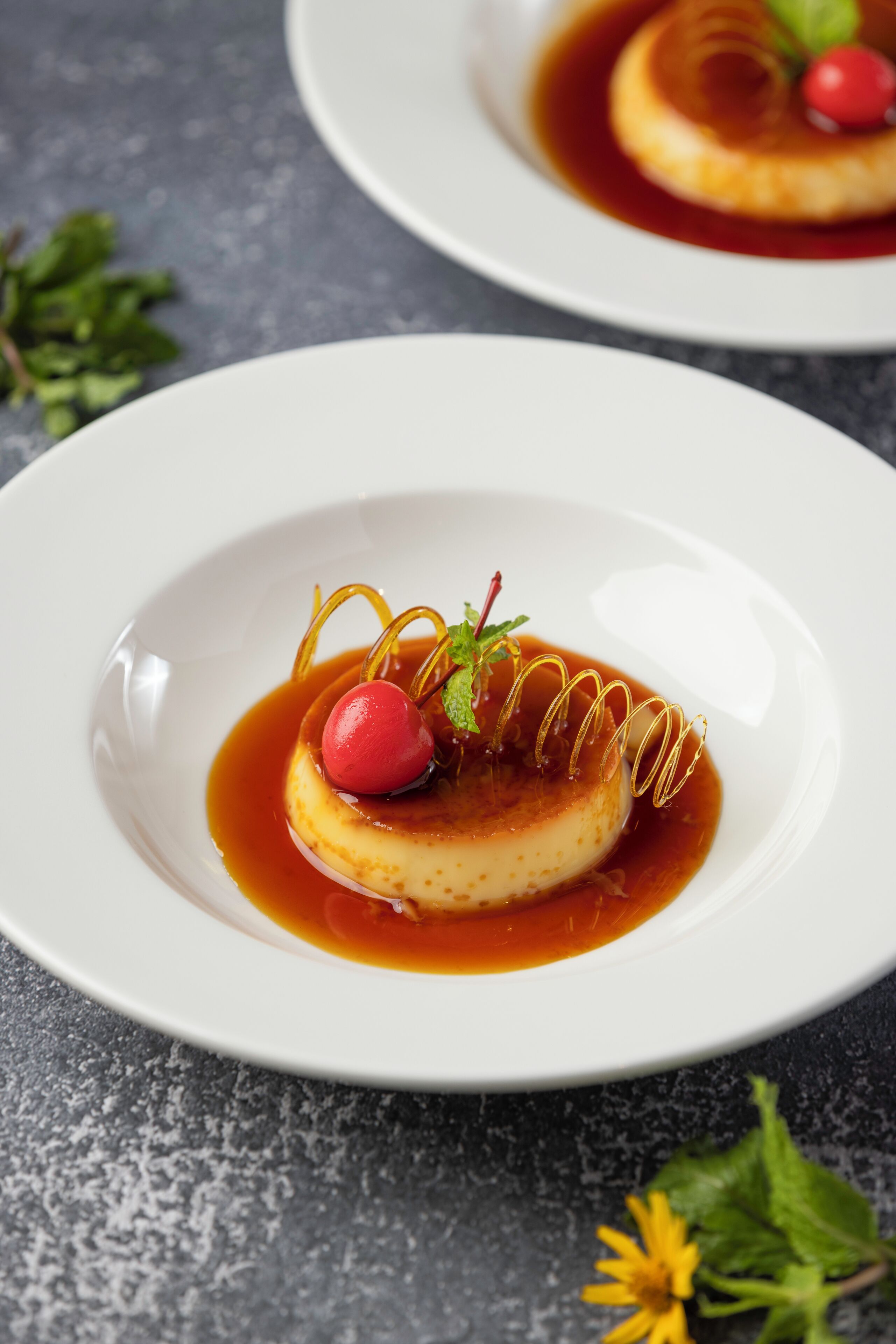 A dessert on a white plate with caramel sauce and a decorative garnish.