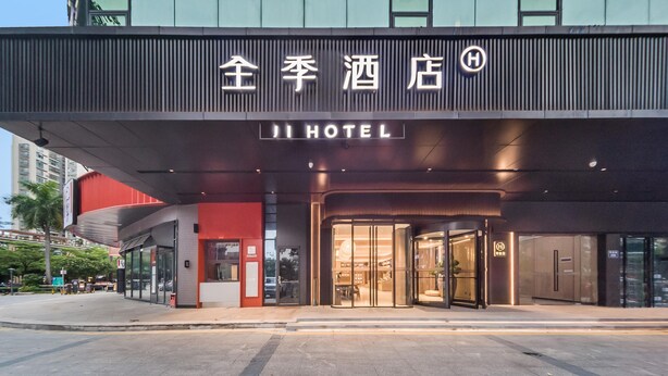 A hotel entrance with a modern design, featuring a prominent sign with Chinese characters and the English name "JI HOTEL". - Ji Hotel Shenzhen Baoan Pingzhou Subway Station (Shenzhen)